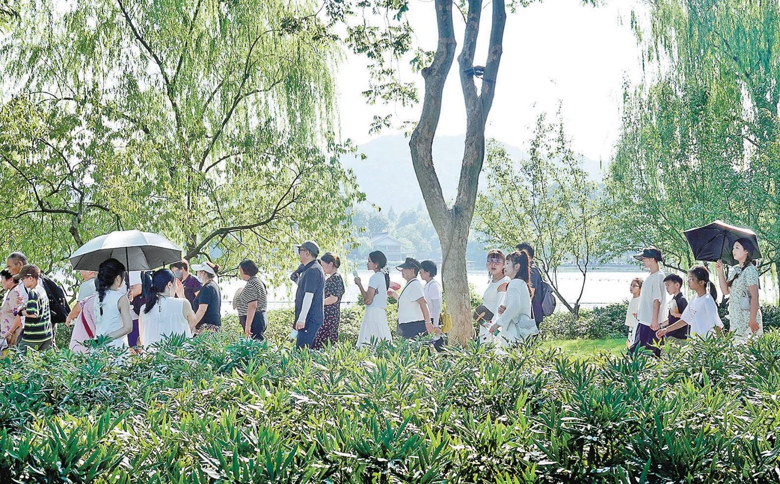 热浪滚滚的苏堤上游人如织。记者 李忠 摄