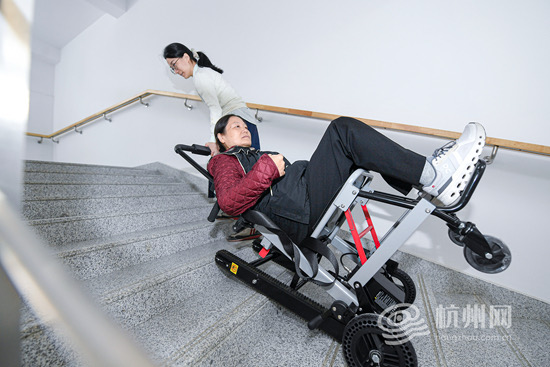 市民谢女士正在使用爬楼轮椅