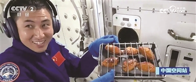 航天员端着烤鸡翅 图据央视新闻