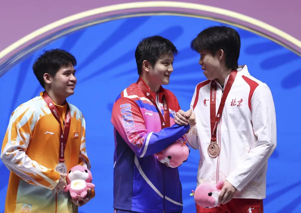 △ 11月16日,冠军上海队选手樊振东(中)与季军北京队选手王楚钦(右)握手致意。新华社记者 陈斌 摄