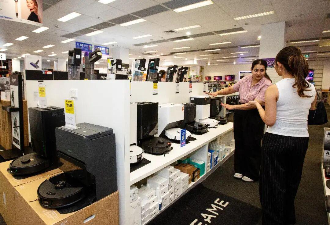 在澳大利亚悉尼市中心一家电器商场内,店员向顾客介绍石头科技的扫地机器人。新华社记者 马平摄