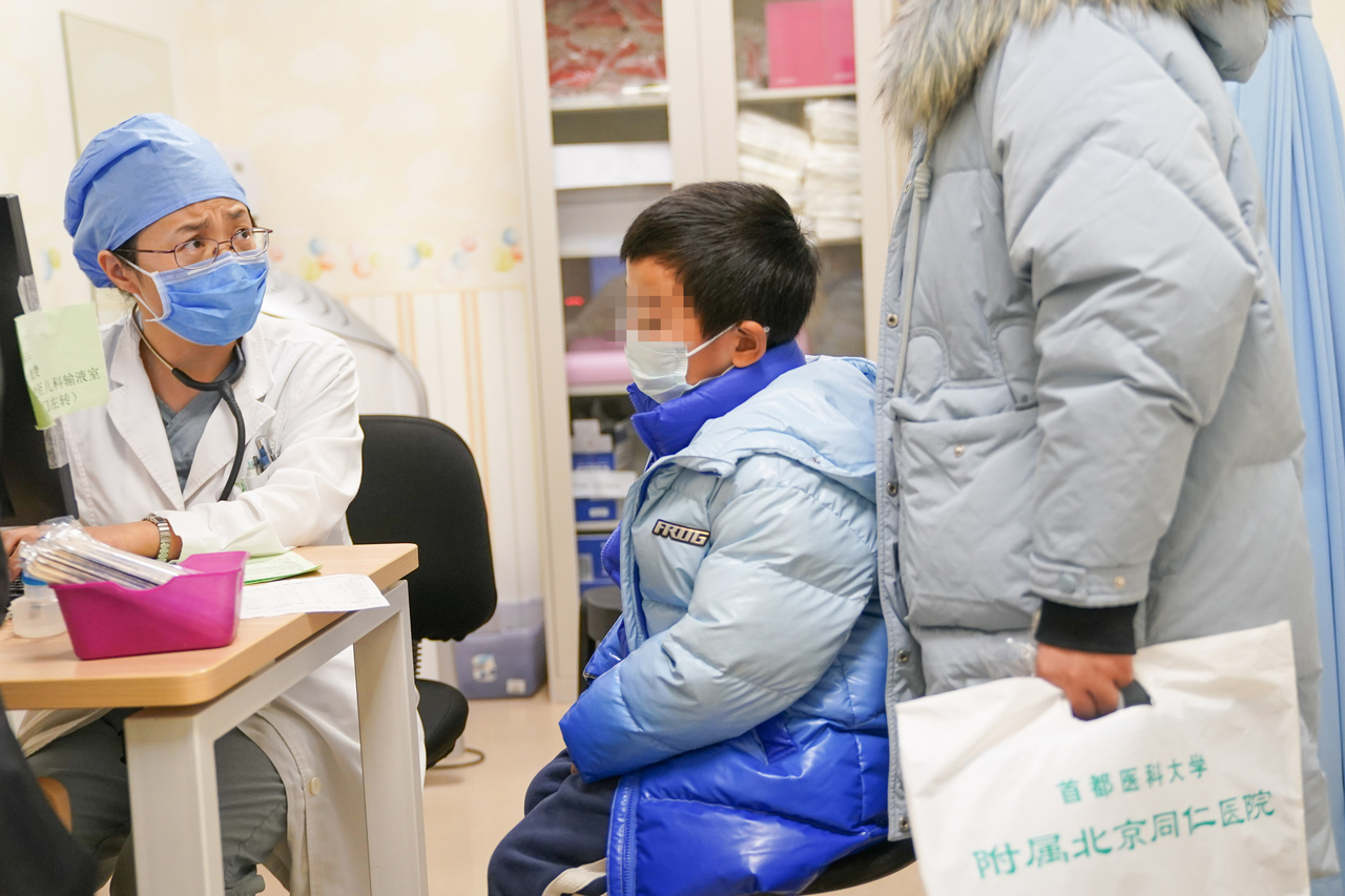 医生在询问孩子病情。图源:新华社