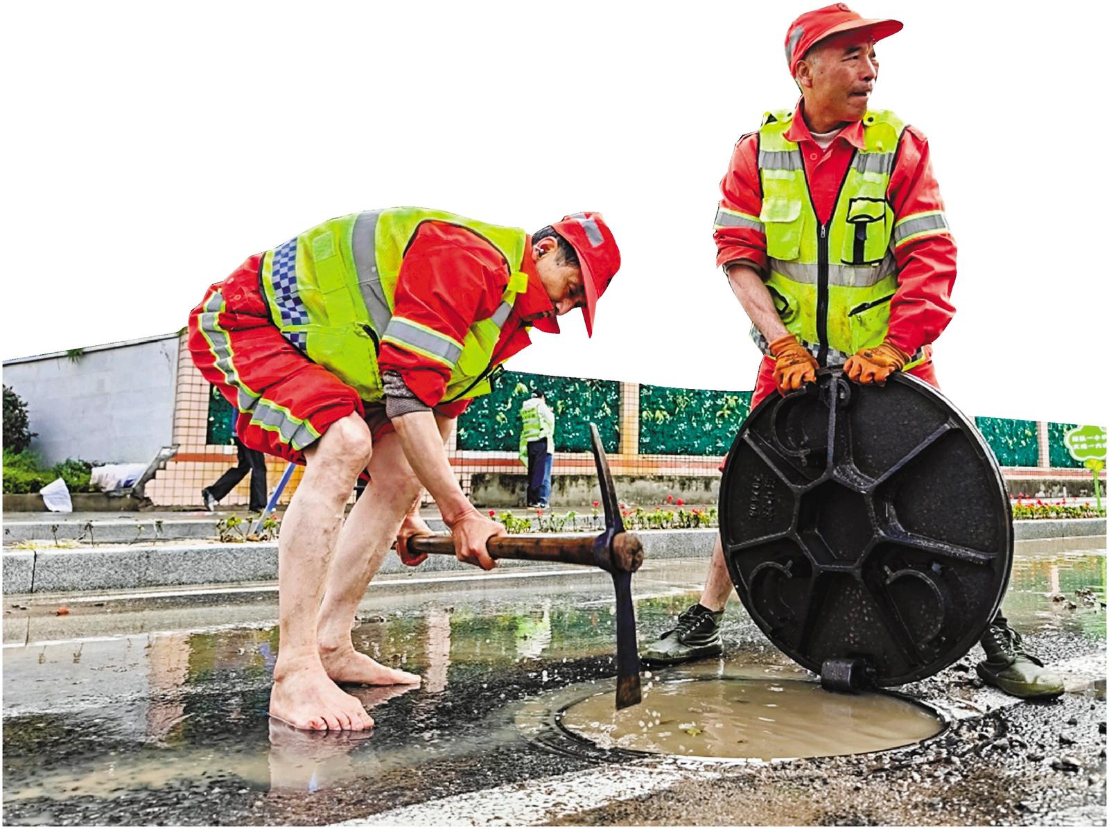 现场工人师傅赤脚进行排水作业。