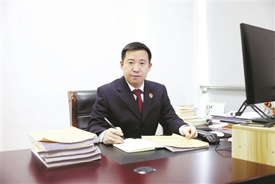 图为夏育宏在办公室翻阅卷宗,找寻办案线索。记者 法鑫 摄