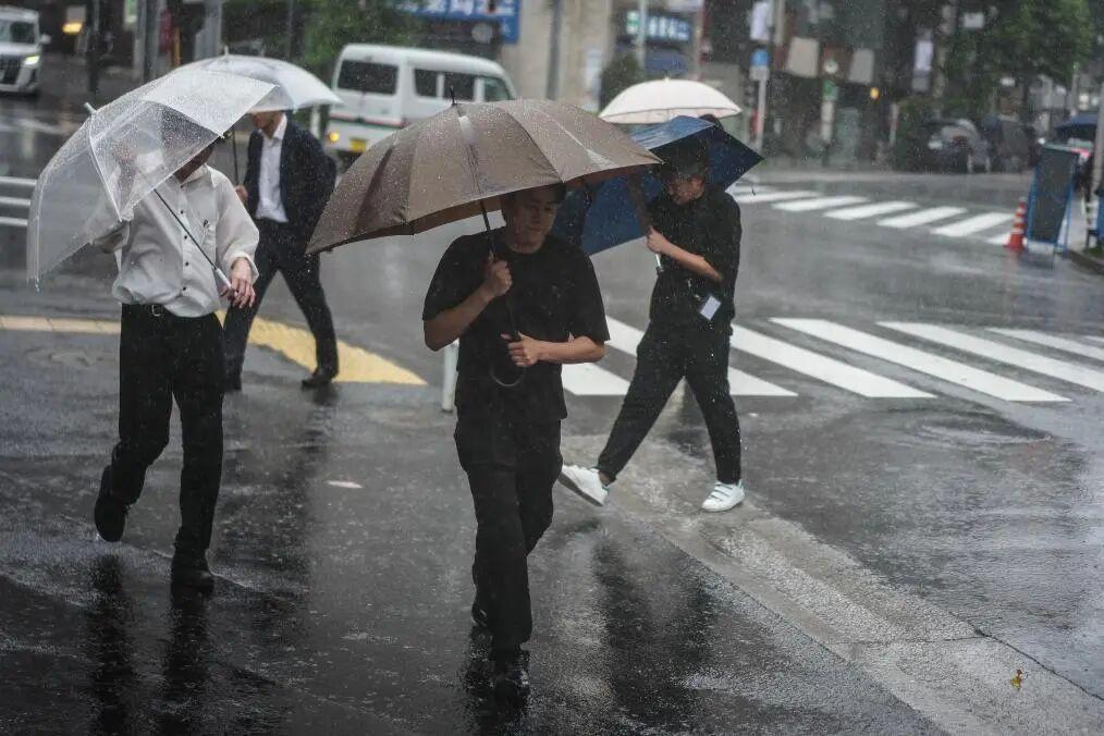 6月3日,在日本东京,行人撑伞在街头行走。新华社记者 贾浩成 摄
