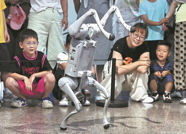 Children and parents watch a robotic dog doing acrobatics at a science and technology museum in Jiaxing, Zhejiang province, on July 18. JIN PENG/FOR CHINA DAILY