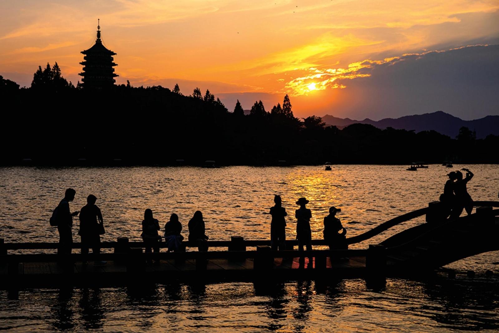 昨天傍晚,游客在西湖边观赏“雷峰夕照”景观。记者 陈中秋 摄