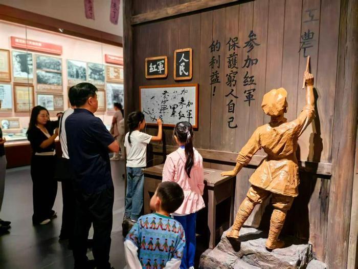 10月3日,少年观众在展厅互动场景中写下“人民红军”“参加红军”。新华社记者魏冠宇 摄